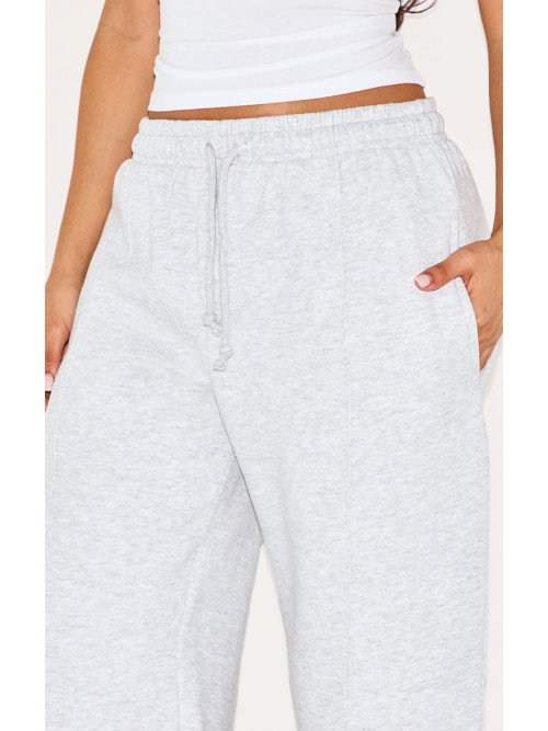 Маленький попелястий сірий пінтук протягує пряму ногу пробіжки