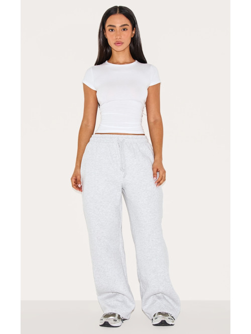 Маленький попелястий сірий пінтук протягує пряму ногу пробіжки