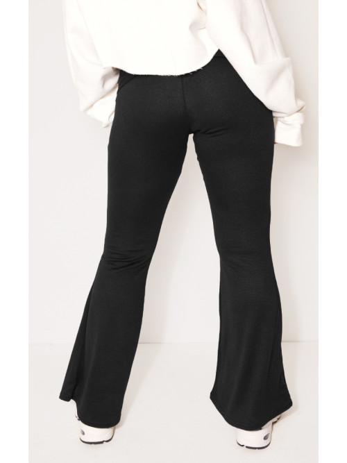 Маленька чорна складка над розкльошеними штанами